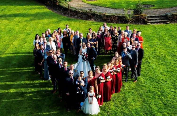 Group photo of the lovely wedding guests in the gardens.