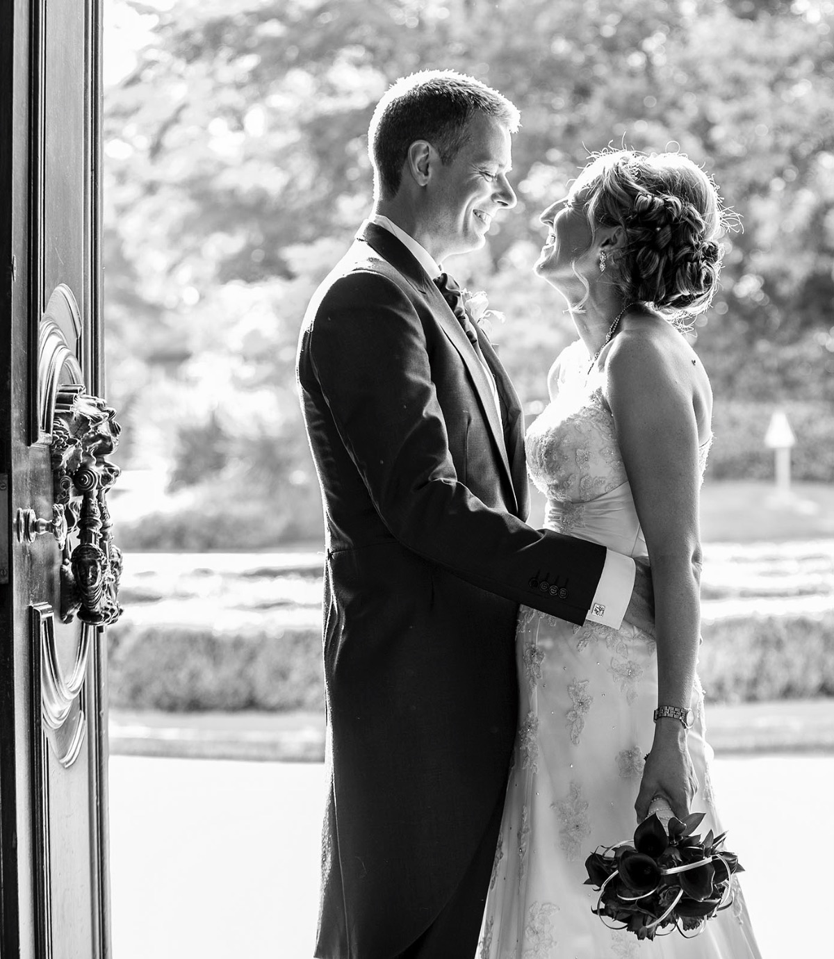 The newlyweds in a lovely naturally lit image at the front door