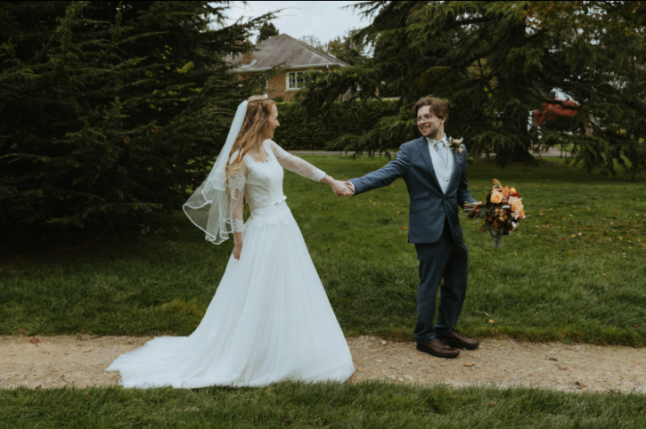 Bride & Groom walk with flowers