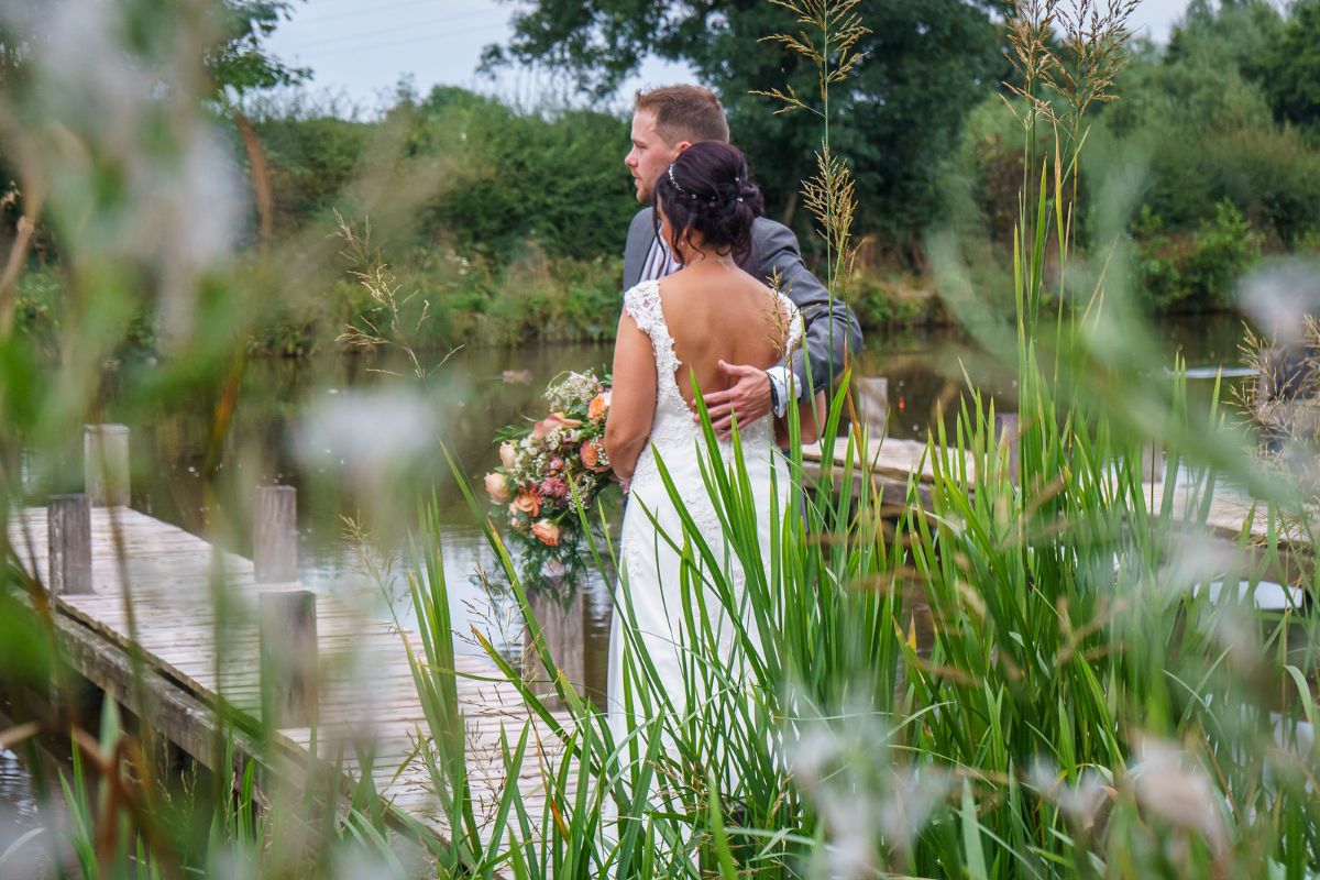 A super shot of the couple down by the water as Jenna and Adam celebrate their wedding day at Lion Quays Resort in Shropshire.