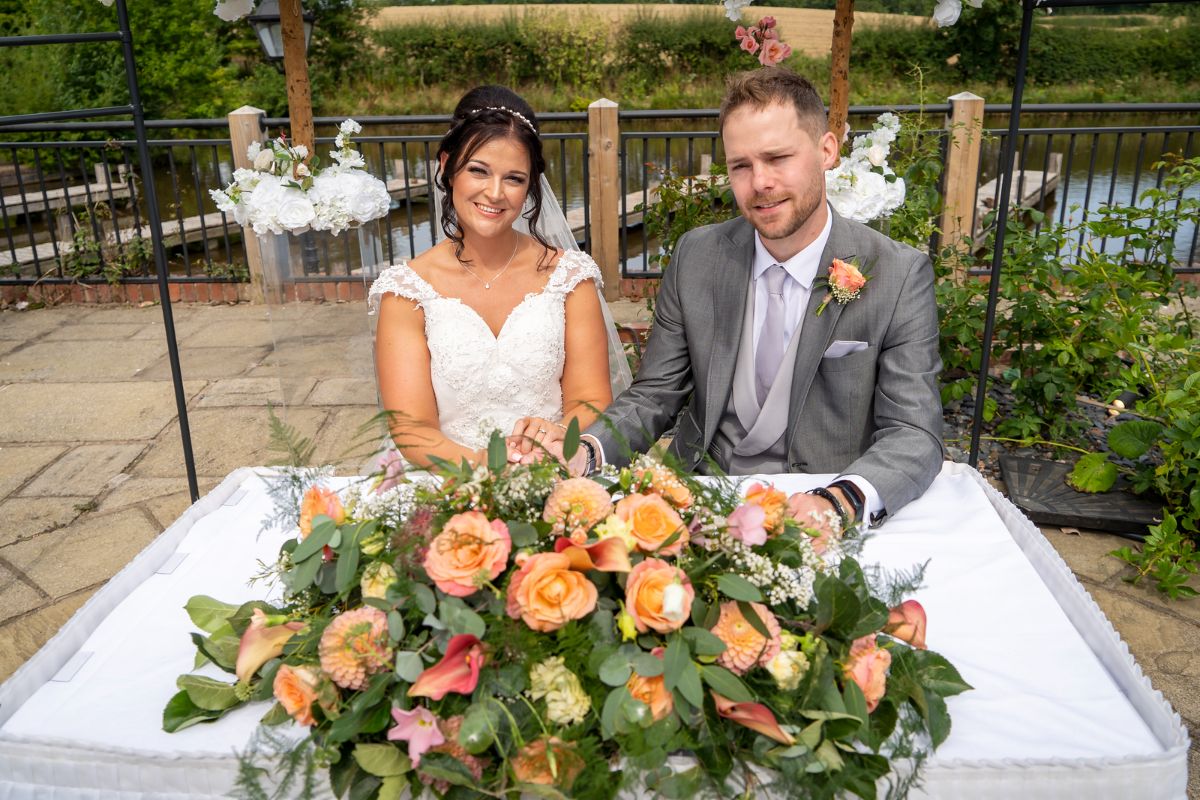 Jenna and Adam sign the register at their wedding day at Lion Quays Resort in Shropshire.