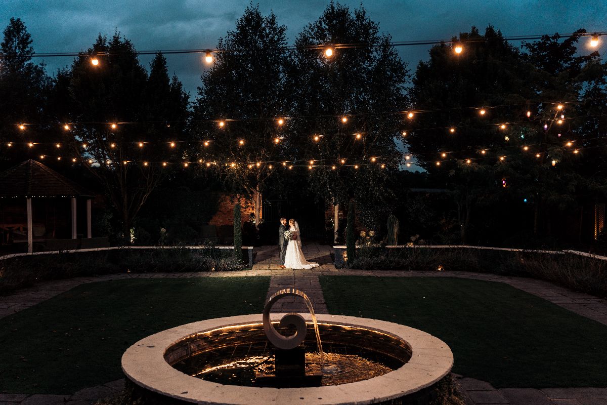 Stunning night time photograph of the happy couple at Jessica and Rhys wedding in the walled garden at Lion Quays Resort in Shropshire.