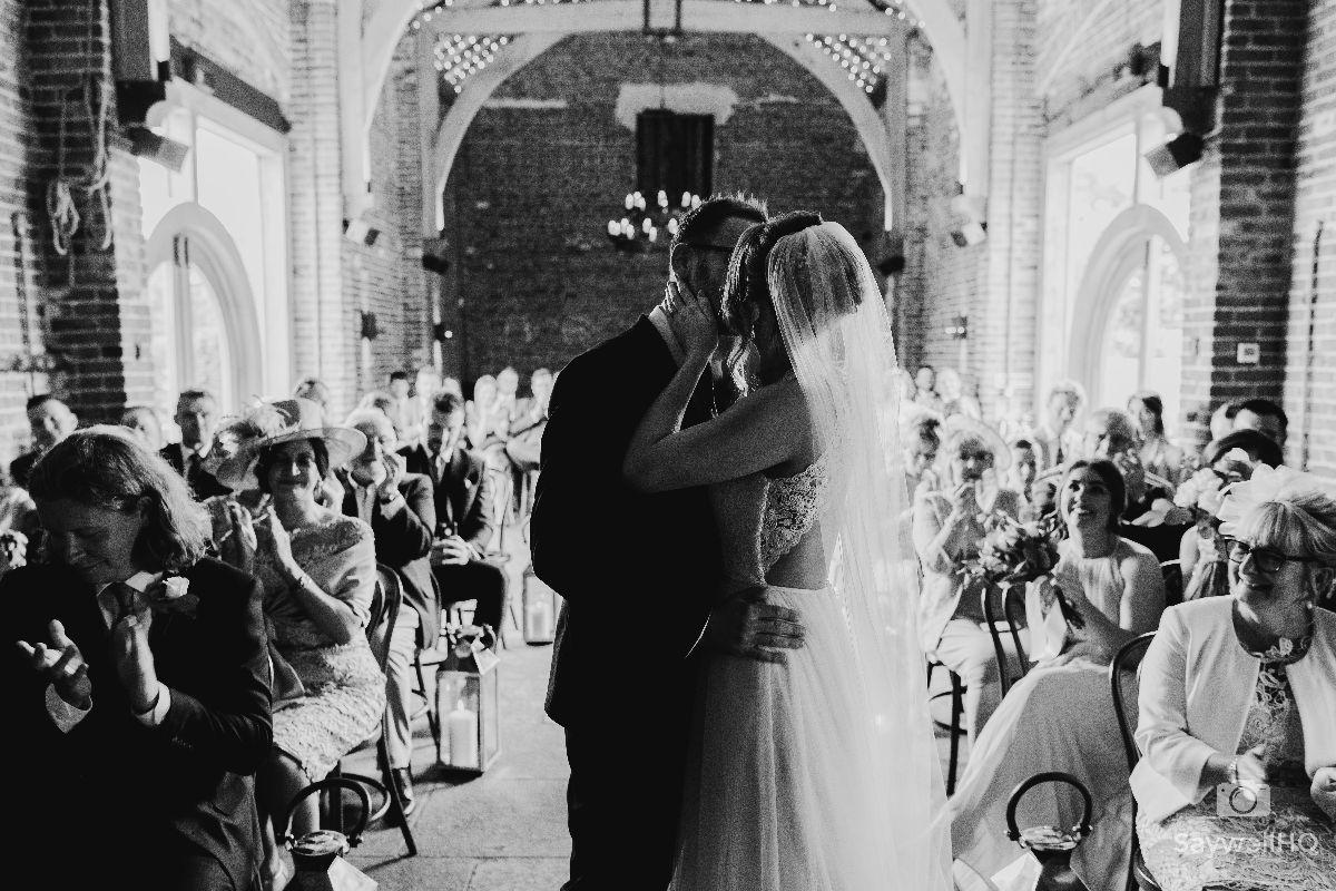 Hazel Gap Barn Wedding Photography - Bride and Groom first kiss