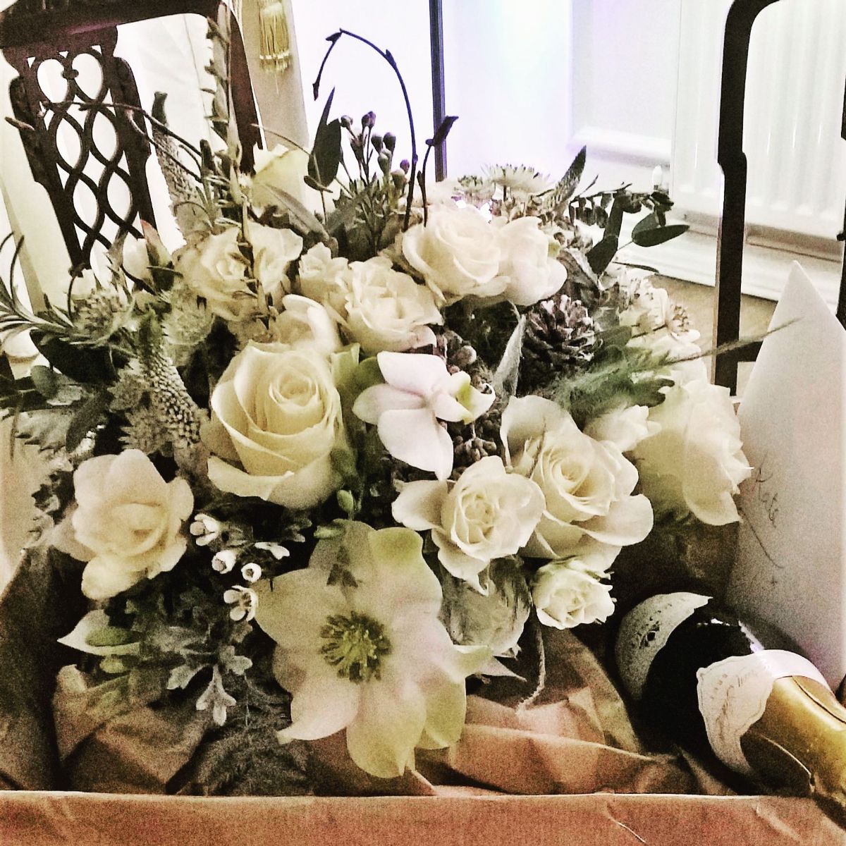 Brides posy of Christmas roses, spary roses, silver grey foliages, freesia and herbs