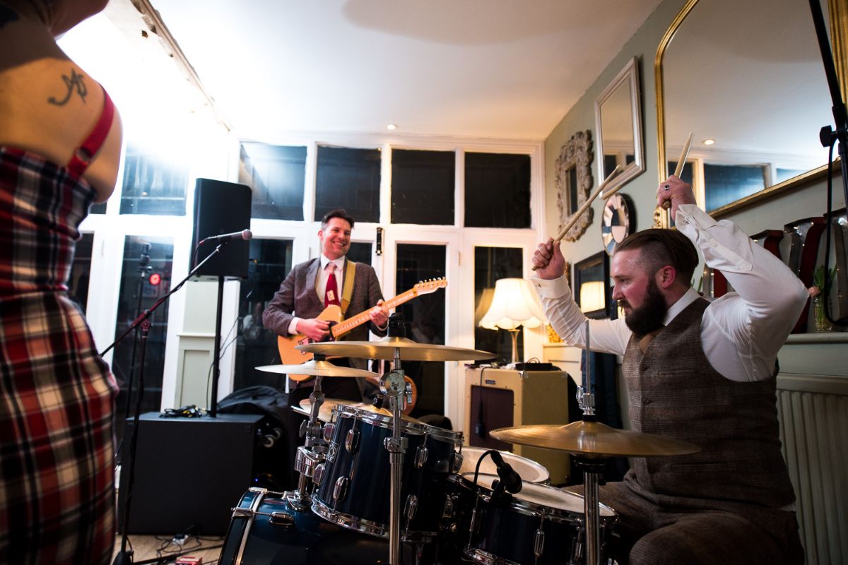 Groom surprises his guests as he joins the band and plays the drums at his won wedding at The Secret Gardens in Ashford