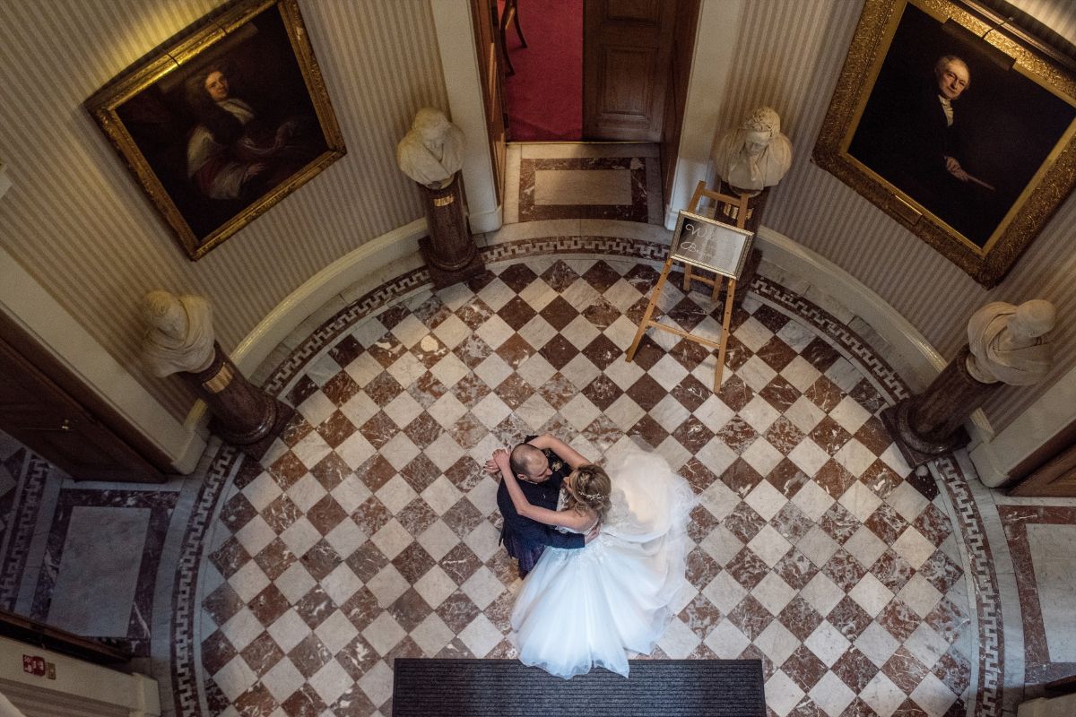 The happy couple take a moment alone in the stunning original entrance to the Playfair Building.