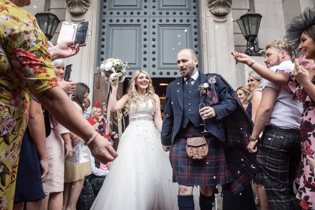 The couple are greeted by guests as husband and wife outside the Playfair Building.