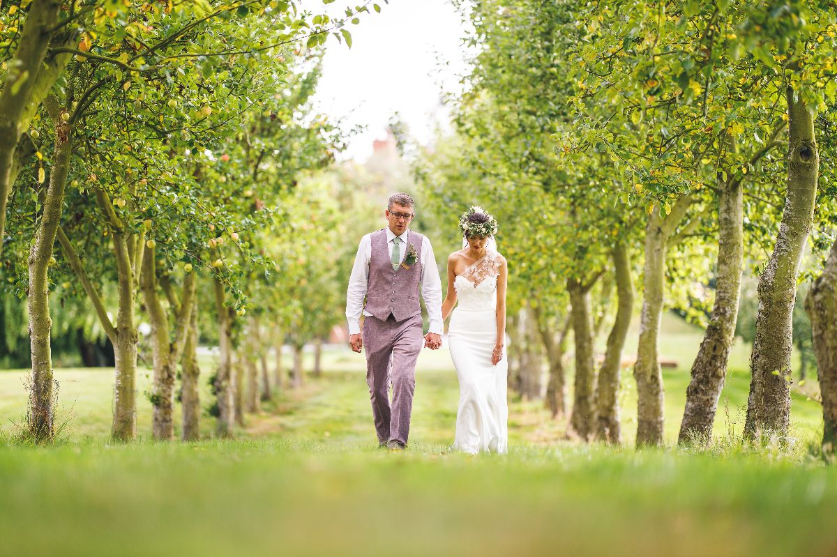 The happy couple strolling in the orchard