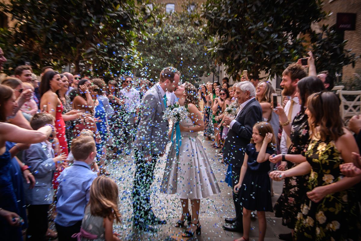 A picture of Sam and Samantha kissing, whilst being showered by confetti and surrounded by their happy guests. This picture captures the atmosphere at this wedding perfectly!