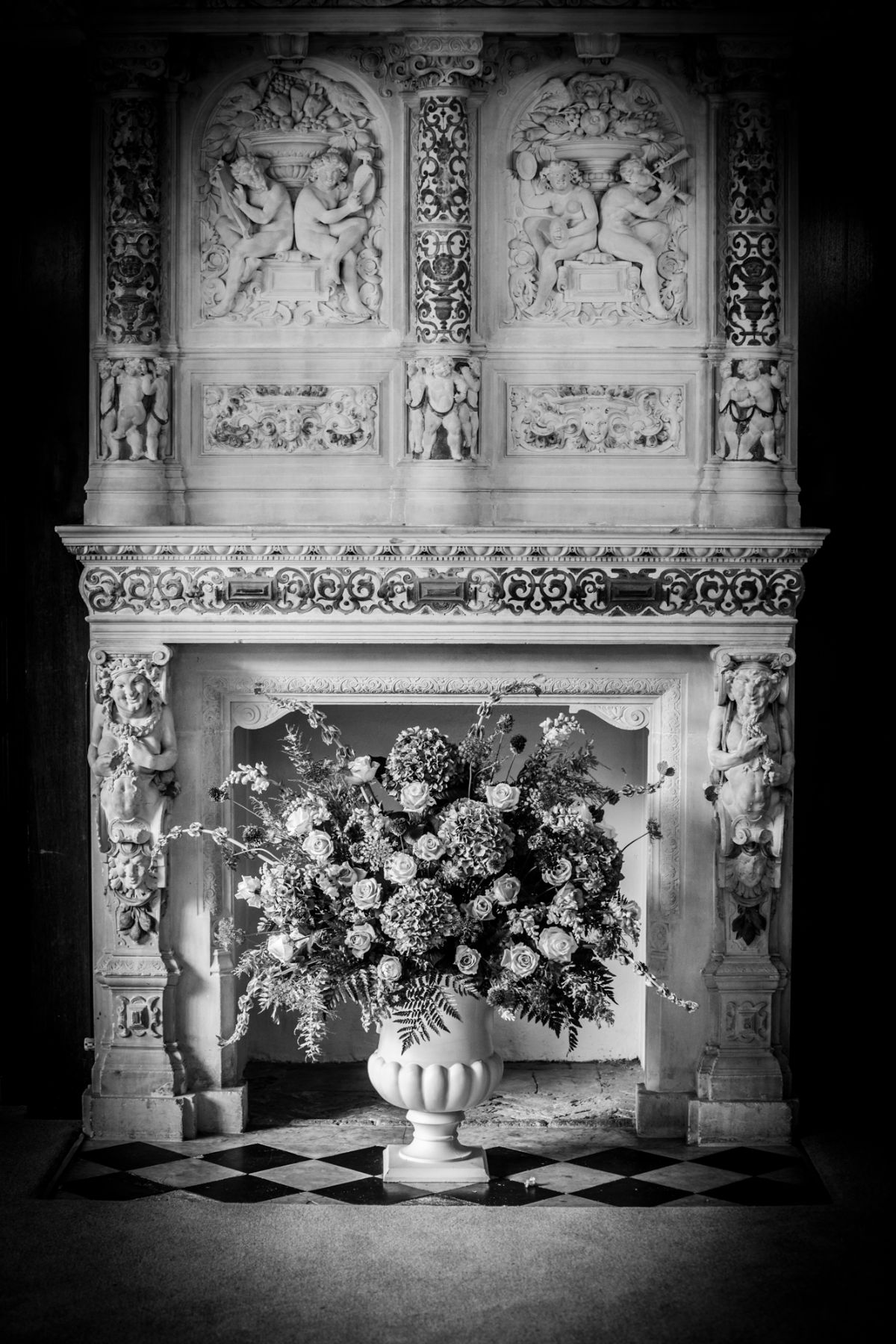 Rothamsted Manor Library's ornate fireplace decorated with a stunning floral design for Amanda and James' wedding ceremony.