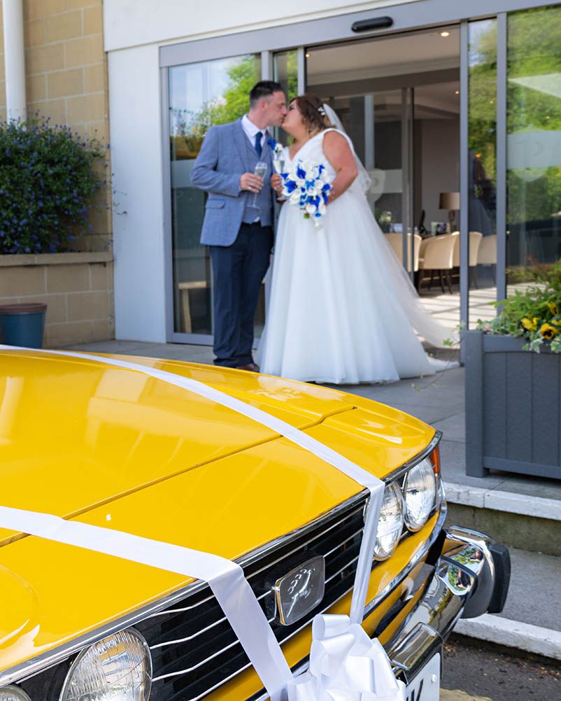 Our kiss with a classic wedding car