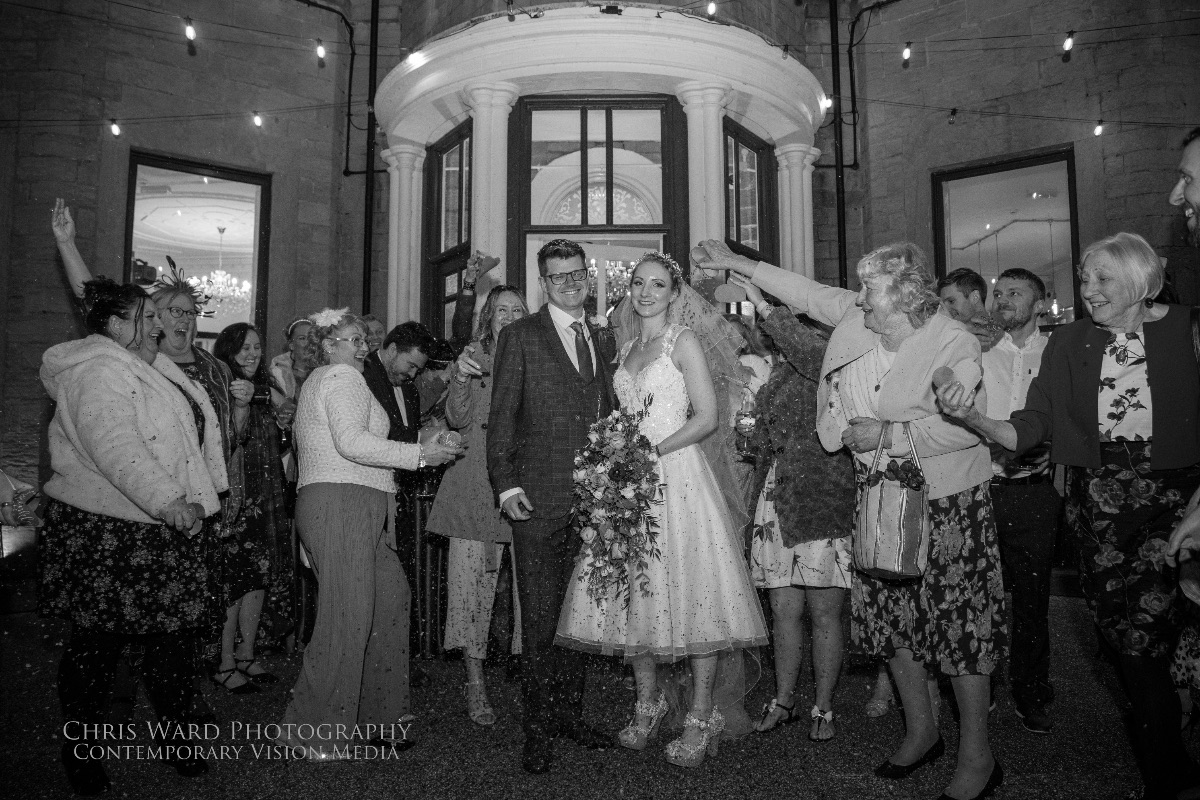 Laura & Dan stand in the terrace as guests throw confetti at Carr Bank Wedding Venue Mansfield Nottinghamshire 