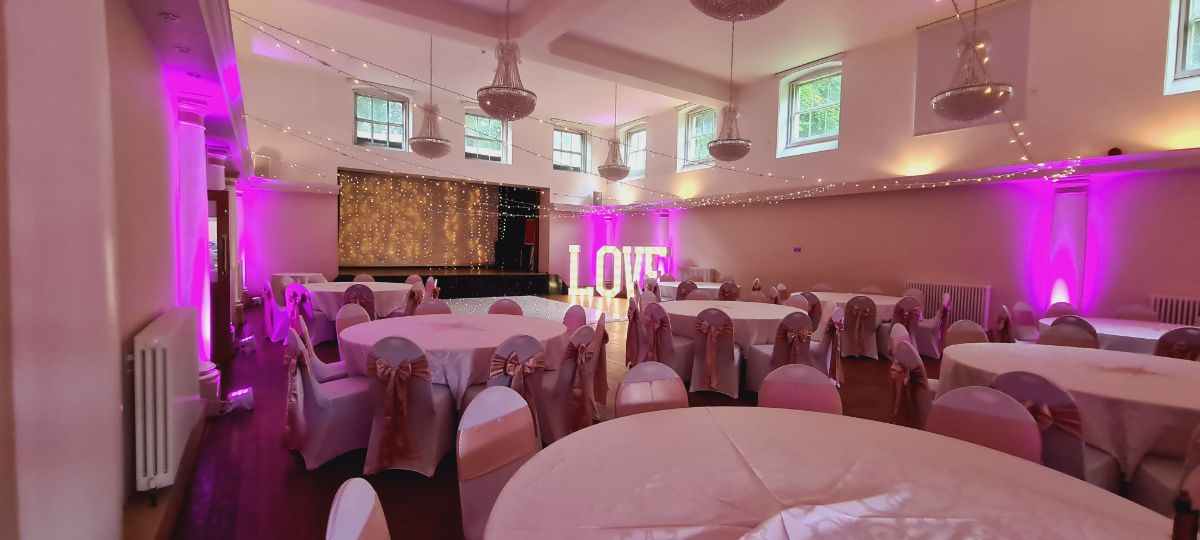 Evening room set up, with fairy light curtain, uplighting and light up love 