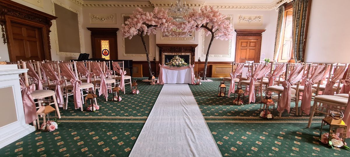 Civil set up with rose gold bows, canopy trees, rose gold lanterns and aisle runner