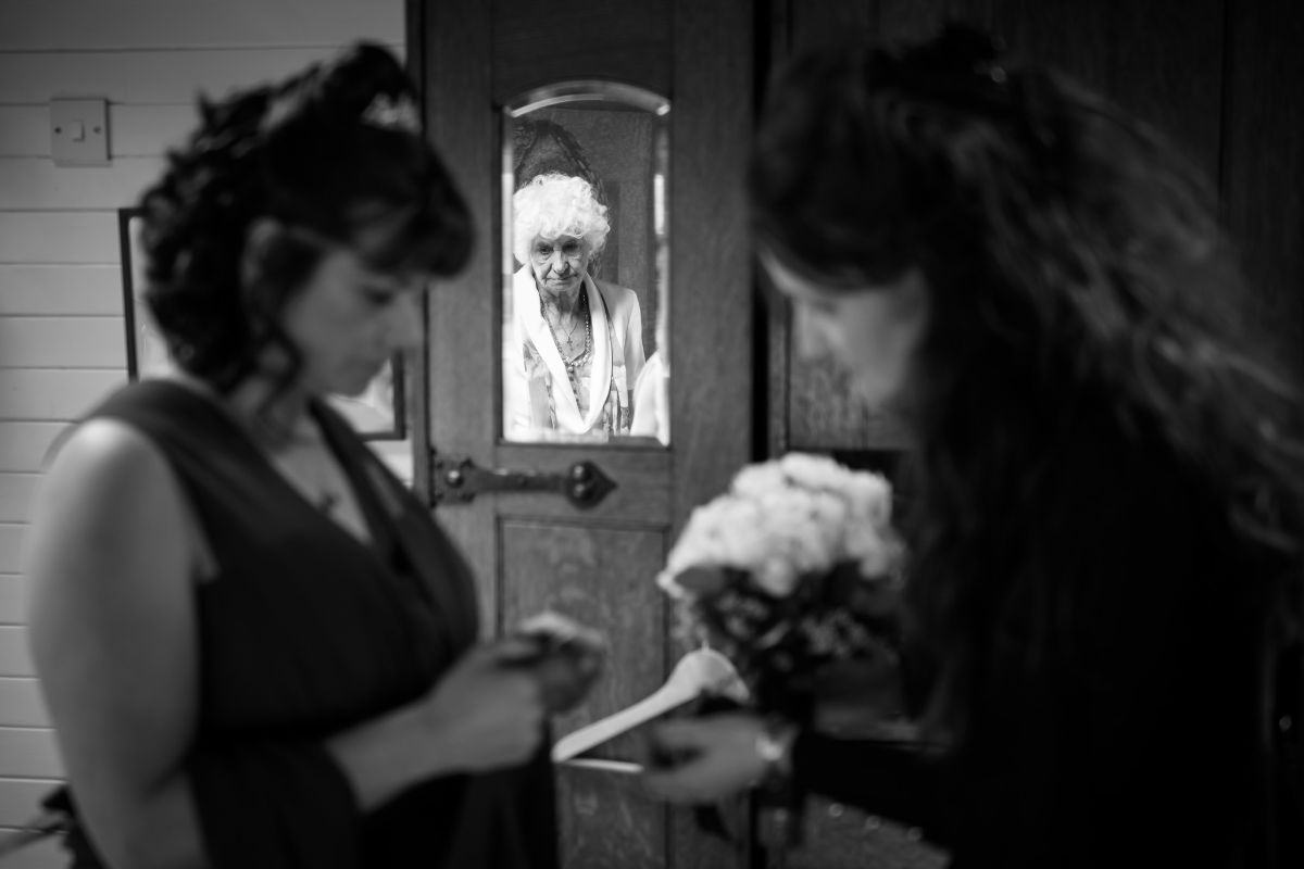 Mother of the bride reflected in the mirror during bridal prep.
