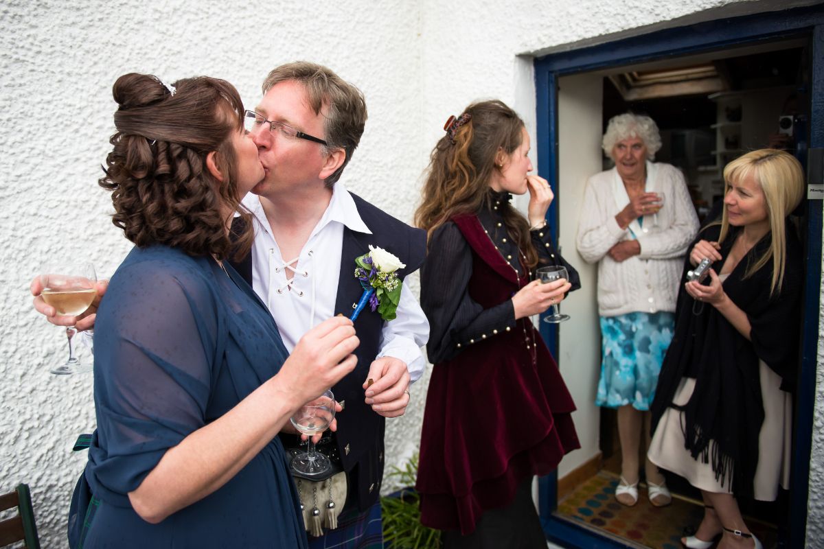 A candid photo of the bride and groom relaxing with their guests and enjoying cigars and whisky!