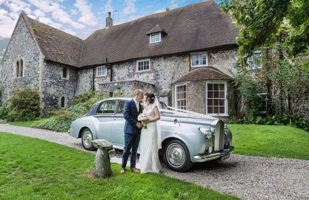 Couple ready to depart with their stylish wedding car.