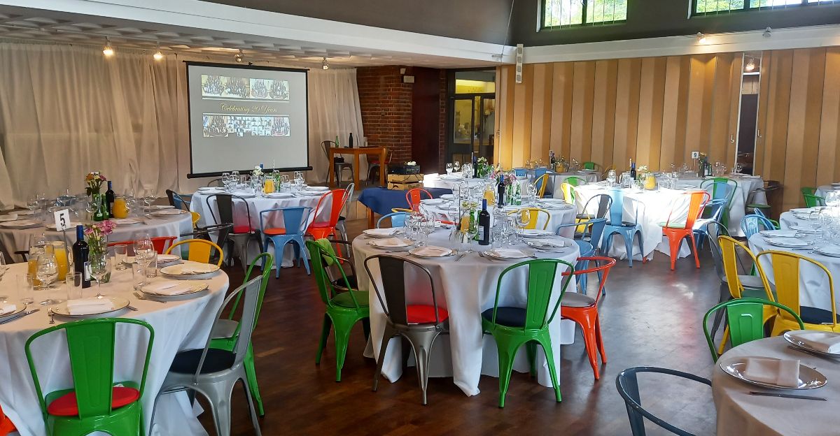 Classic white china, silver cutlery, white table linen and colourful chairs