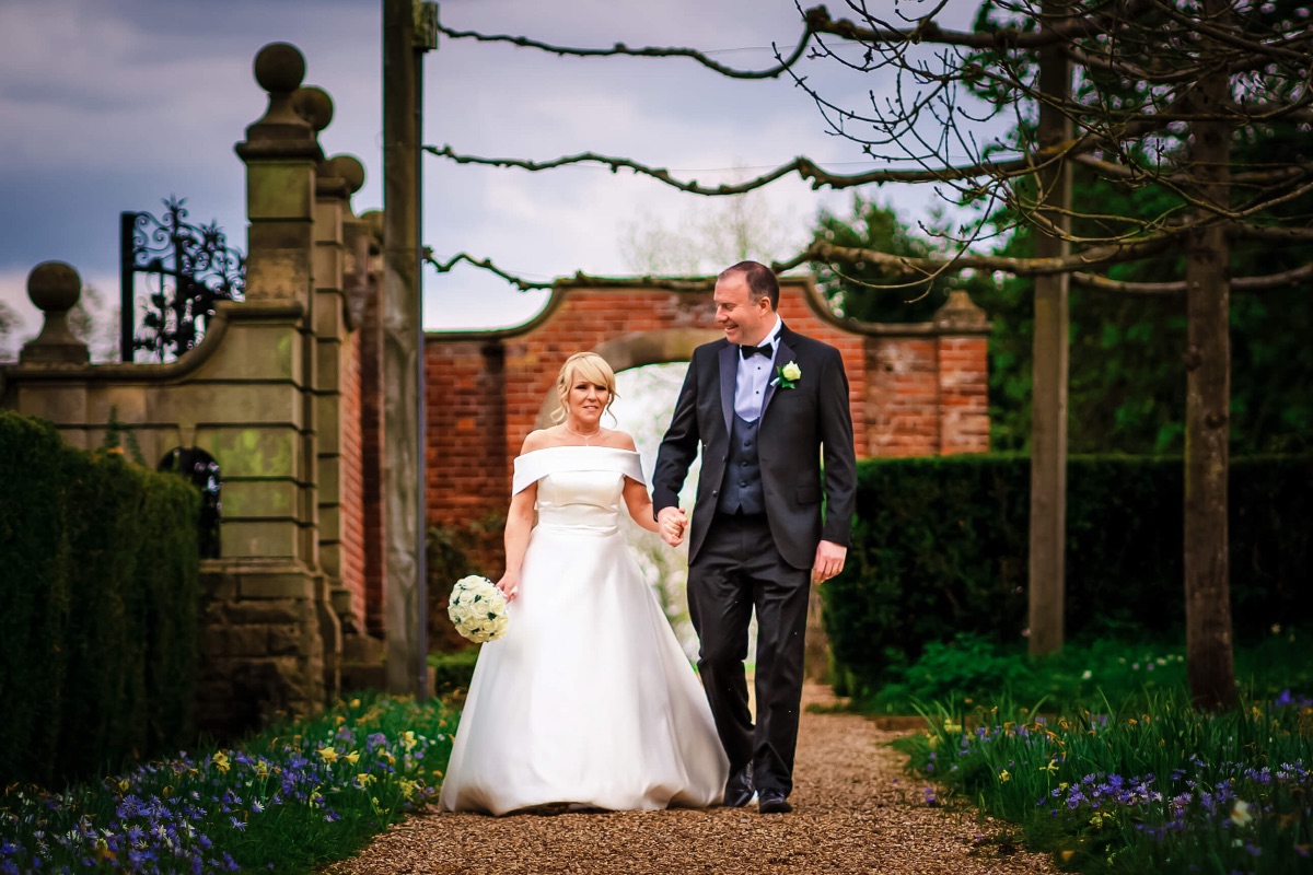 The bride and groom take a stroll in the grounds of Fanhams Hall