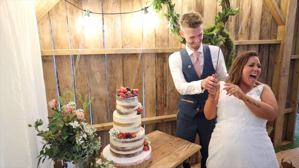The bride and groom share a joke as they cut their beautiful cake