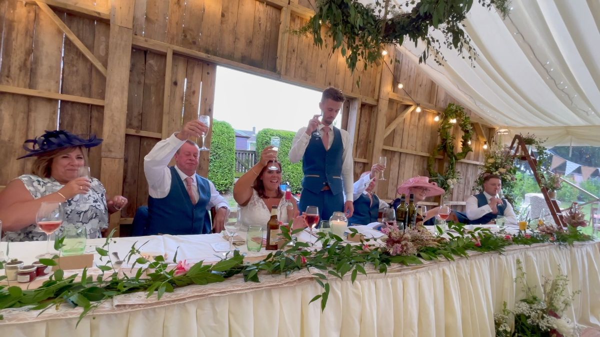 The groom raises a toast to his wife