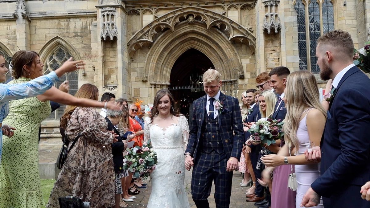 The wedding guests shower the new bride and groom with confetti 