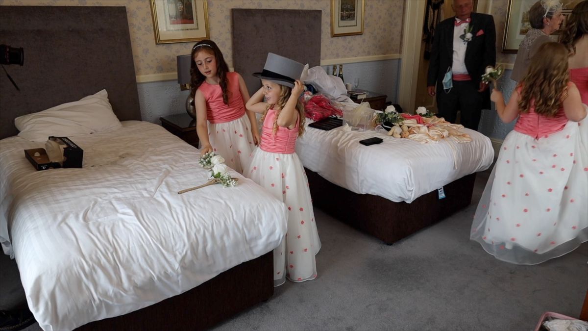 The smaller bridesmaids try on a top hat for size