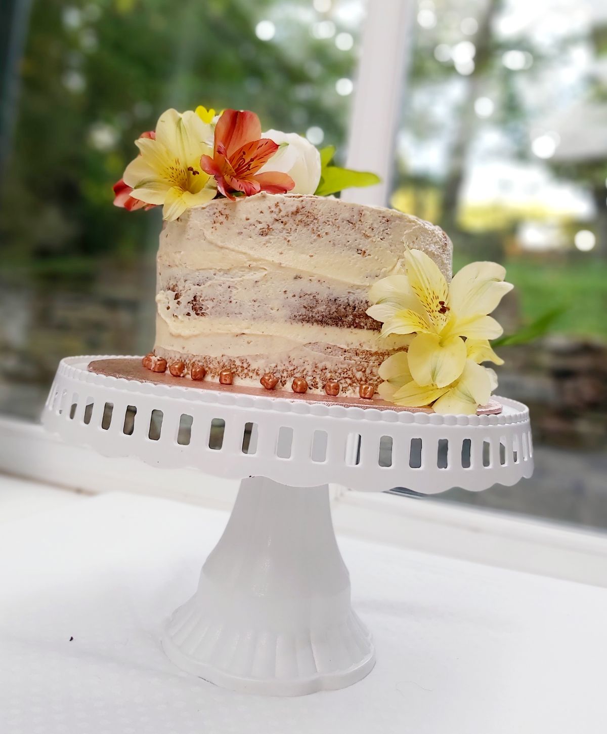 Naked Lemon Cake covered with lemon buttercream decorated with silk flowers 