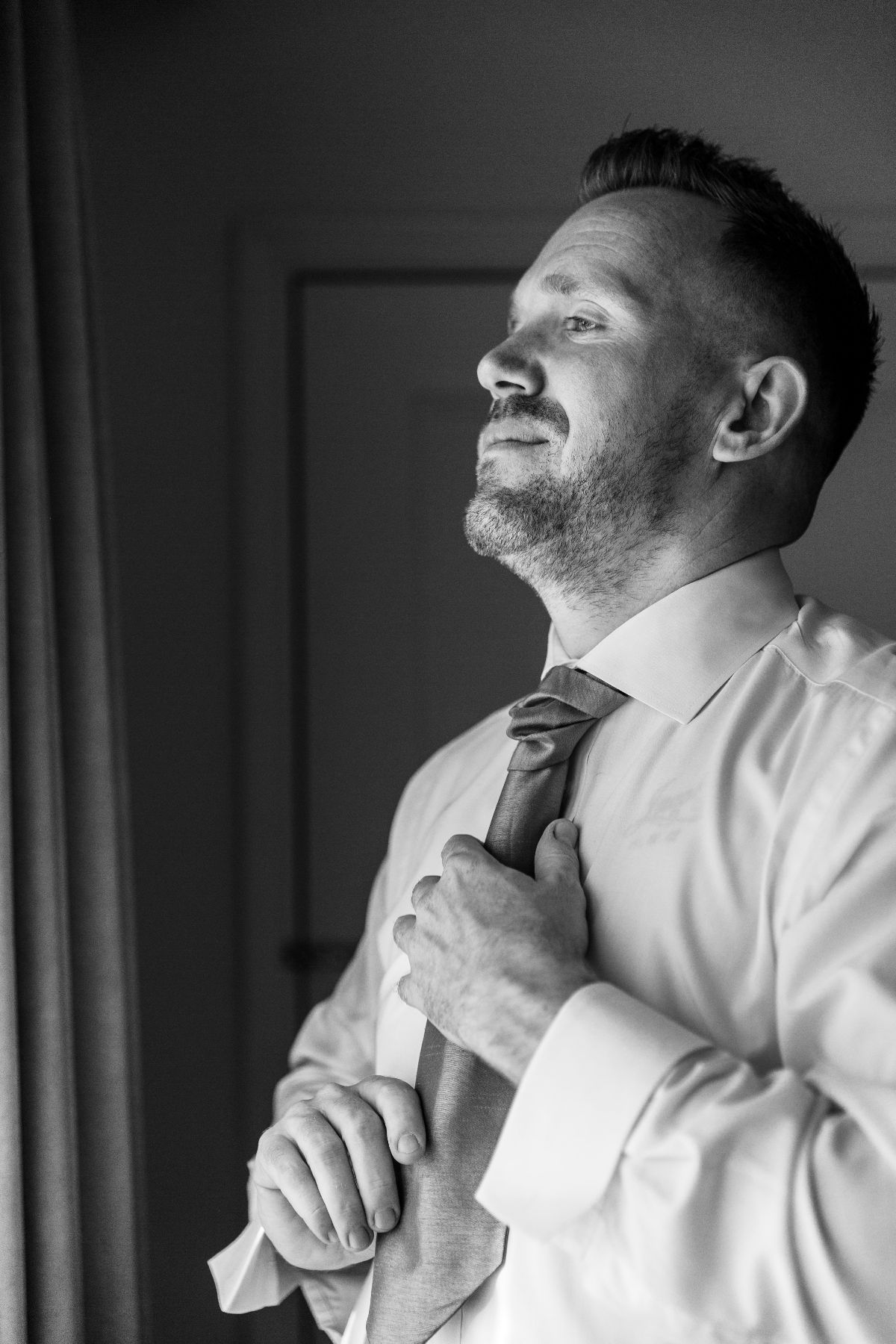 The Groom adjusts his tie at The Hilton Hotel, Leicester...