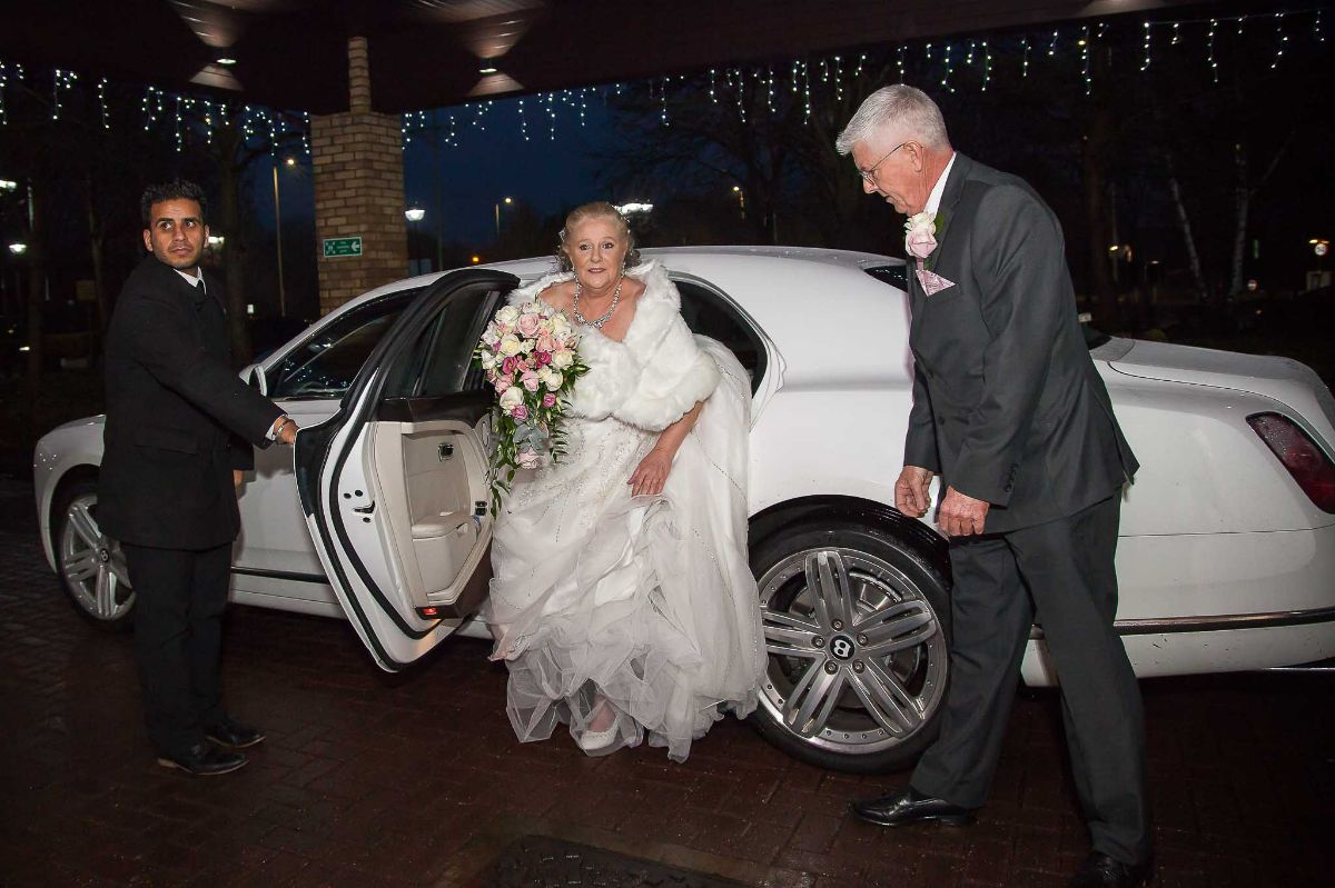 The Bride has just arrived and getting out of the limousine. 
