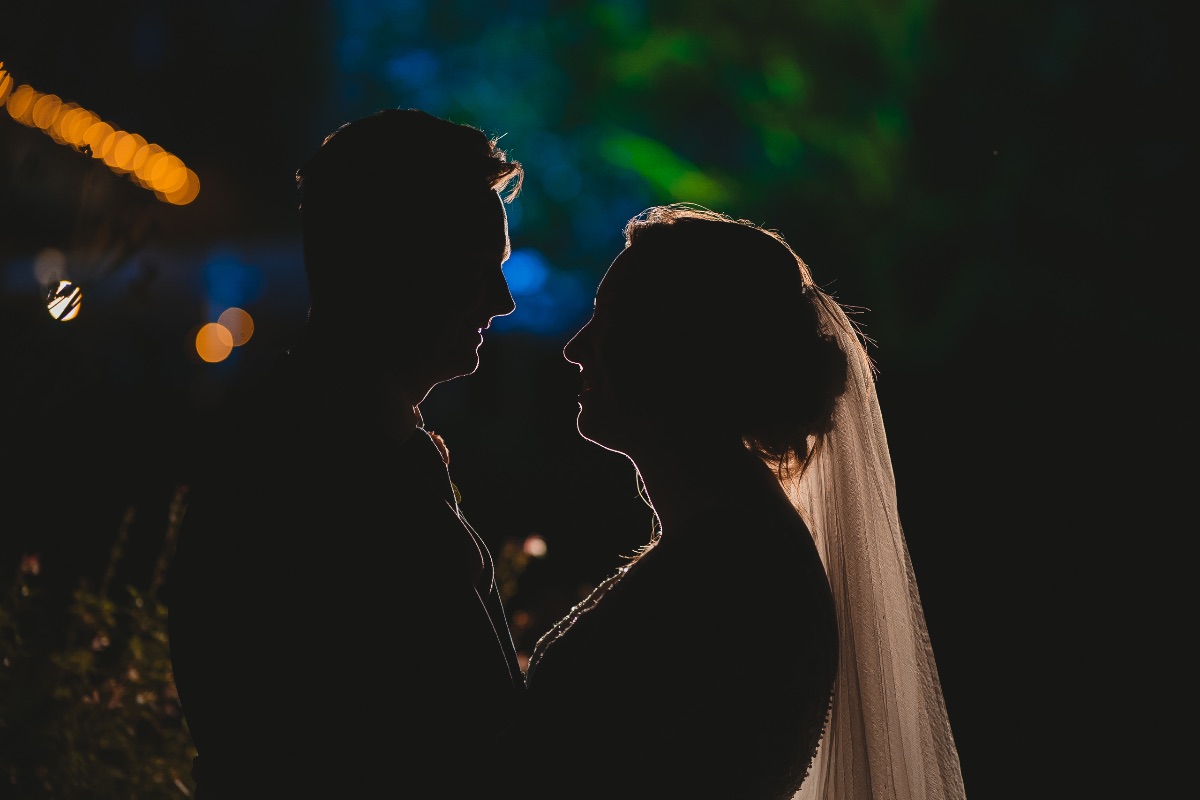 Silouhette photo of Bride and groom sharing a romantic moment.