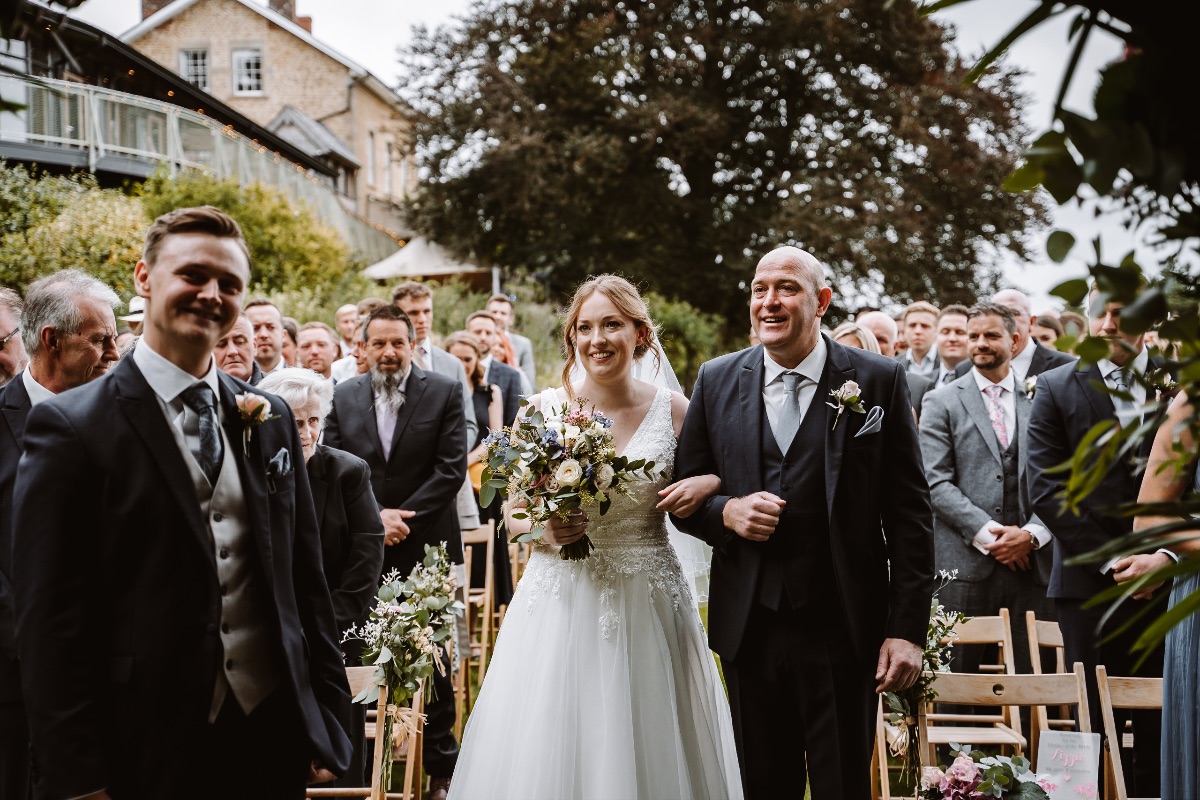 Father walks her daughter up the aisle to meed groom