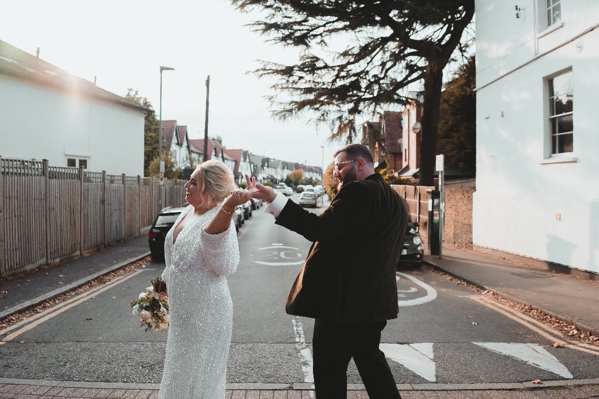 Bride and groom spinning around as they walk the streets