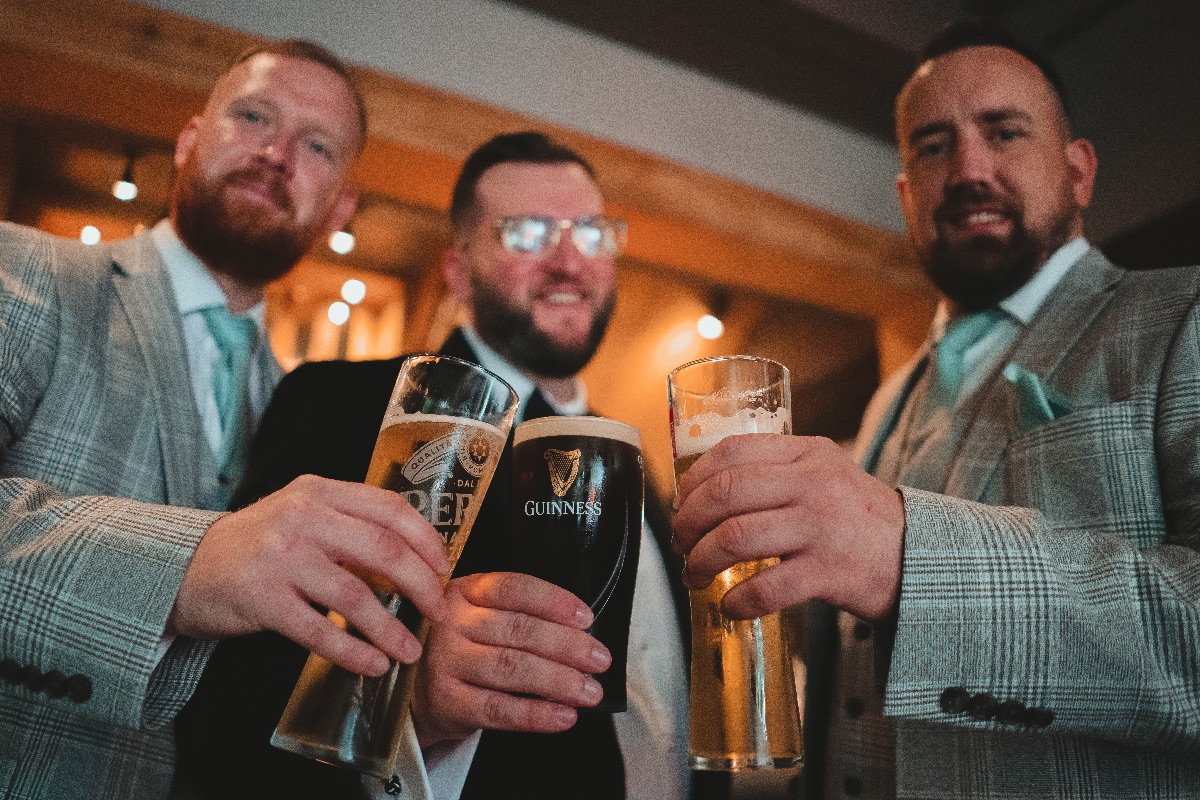 Groom has a drink with his groomsmen