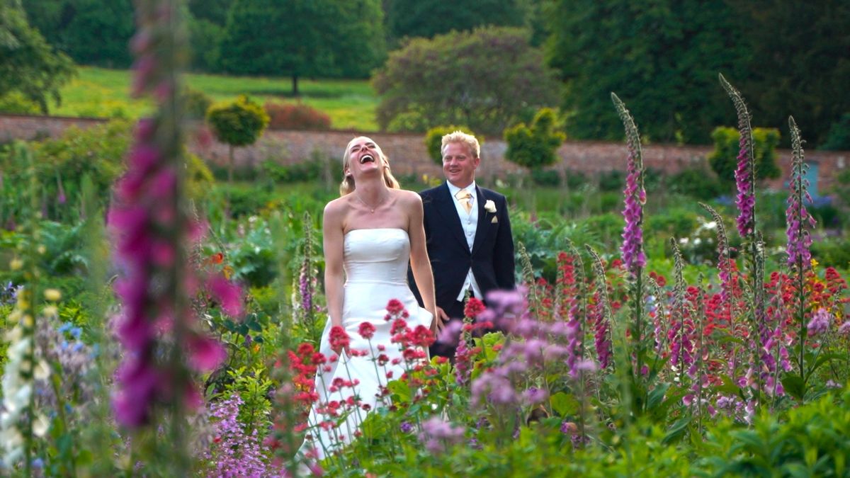Steph and Tim laughing in the Gardens at Kelmarsh Hall whilst we filmed their portrait shots.