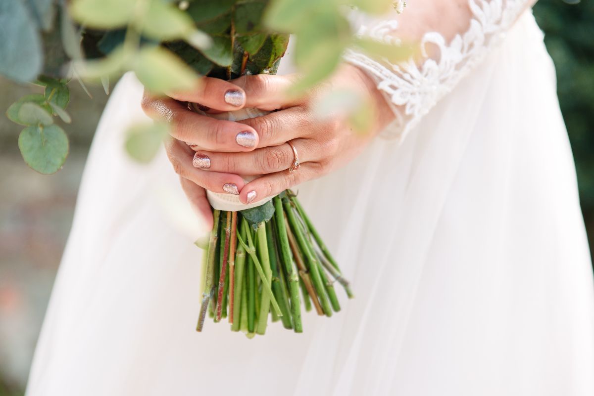 engagement ring sparkling whilst holding her wedding bouquet