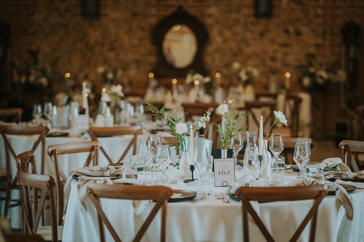 Beautiful fresh foliage and white flowers added simplistic detail to create a timeless wedding breakfast set up